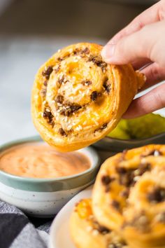 a person is dipping some food into small bowls