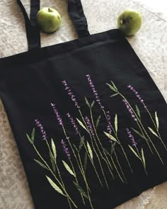 an embroidered tote bag with purple flowers and green apples