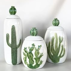 three ceramic containers with cactus designs on them