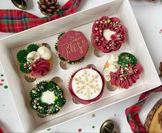 there are many decorated cupcakes in the box