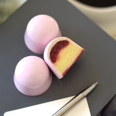 three pieces of cake sitting on top of a table next to two eggs and a pen