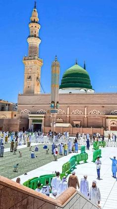 people are walking around in front of a large building with a green dome on top