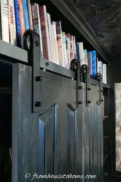 the bookshelf is filled with many different types of books and has black metal doors