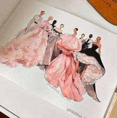 an image of some women in pink dresses on a white table with a wooden box