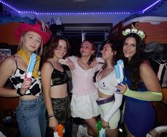 four girls are posing for the camera with toothbrushes in their hands and wearing costumes