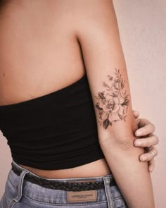 a woman's arm with a flower tattoo on the left side of her body