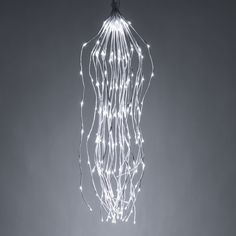 a chandelier with white lights hanging from it's sides on a gray background