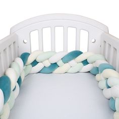 a white crib with blue and white rope on it