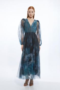 Prepare To Turn Heads In Our Mini Dress, Designed To Make A Statement. It Features A Deep V Neckline And A Universally Flattering Fit And Flare Silhouette, While Sheer Balloon Sleeves Offer An Ethereal Element. Complete With A Full Skirt At A Mini Length, This Style Cinches In At The Waist, Balancing The Figure And Making It Easy To Style. Blurred Floral Tulle Plunge Maxi Dress Premium Tulle Fabric Figure-Fitting Waist Lightweight Sheer Fabric  Plunge Neckline V Back Accent Voluminous Balloon Sl Sheer V-neck Maxi Dress For Cocktail, Sheer Silk V-neck Dress, Bride Jumpsuit, Petite Wedding Guest Dresses, Latest Maxi Dresses, Plunge Maxi Dress, Summer Bridesmaid Dresses, Maxi Dress Collection, Outfits Petite