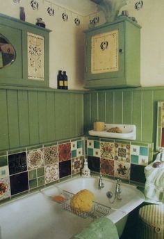 a bathroom with green and white tiles on the bathtub, sink and towel rack