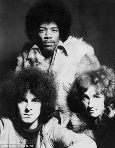 two men and a woman are posing for a black and white photo with their hair blowing in the wind