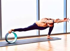 a man doing a yoga pose on a mat with a ring around his waist and legs