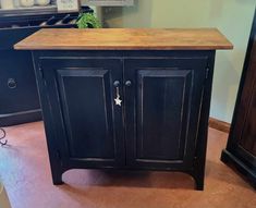 a black cabinet with wooden top in a room