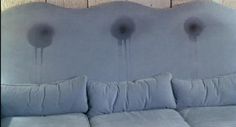 a couch with pillows on it in front of a wooden wall