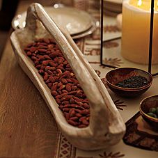 a table topped with plates and bowls filled with food next to candlelight holders on top of a wooden table