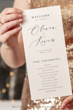 a woman holding up a white wedding program