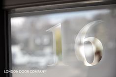 the number sixteen is etched in glass on a building's window sill,