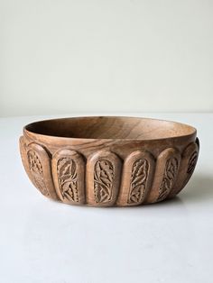 a wooden bowl sitting on top of a white table