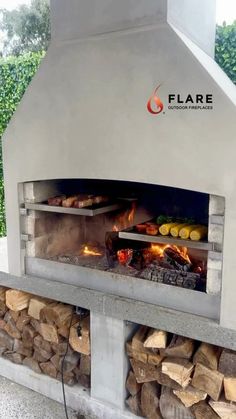 an outdoor pizza oven with firewood stacked in it's center and flames coming out