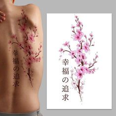 the back of a woman with tattoos on her body and flowers in chinese characters behind it