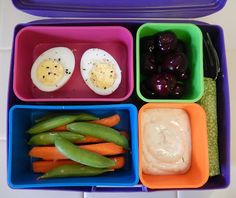 a lunch box filled with different types of vegetables and fruit in it's trays