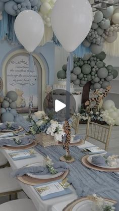 a table set up for a baby shower with balloons