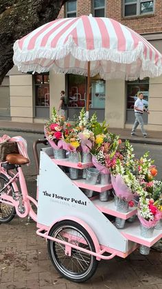 a pink and white bike with flowers on the back