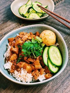 two bowls filled with rice, meat and cucumbers