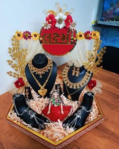 an assortment of jewelry on display in a box with flowers and other items around it