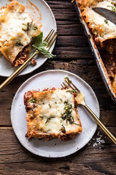 two plates with lasagna casserole on them and one has a fork