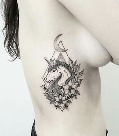 a woman with a tattoo on her chest has a unicorn head and flowers around it