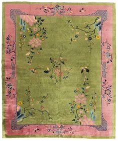 a green rug with pink and blue flowers on the bottom, in front of a white background