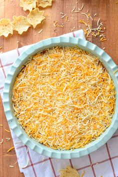 a pie dish with cheese and tortilla chips next to it on a table