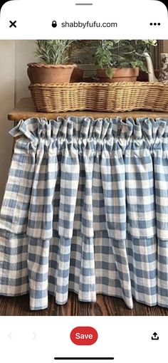 a blue and white checkered bed skirt with ruffles on the bottom, in front of a basket