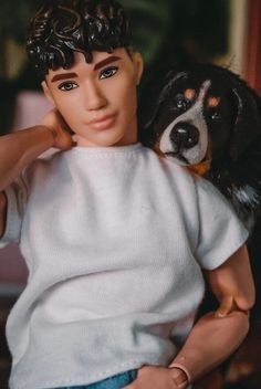 a close up of a doll with a dog on his back and one hand on the head