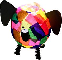 a multicolored animal made out of different colored papers and black legs, with one eye open