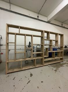 an empty room with several wooden shelves and tools on the floor in front of it