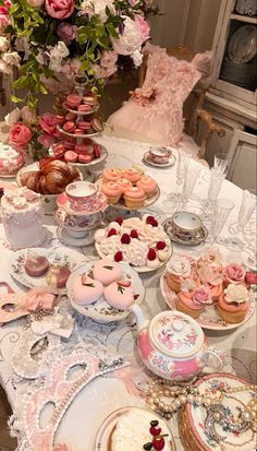 a table topped with lots of different types of cakes and cupcakes on top of plates