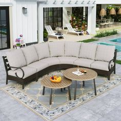 a large sectional couch sitting on top of a rug next to a swimming pool