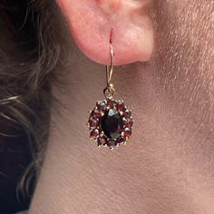 Prized for their striking cherry wine color and distinct inner glow, the now-extinct Bohemian garnet make for a rare antique find. These eye-catching statement earrings are a stunning example of Victorian-era craftsmanship that perfectly showcase the natural beauty of these bewitching gemstones. Handcrafted in the Victorian era Drop-style earrings each approx. 13mm in diameter feature 12 Bohemian garnets approx. 2mm Center oval garnets measure approx. 8 x 6mm Set on new 14k ear wires Because we Garnet Gemstone Earrings, Classic Garnet Jewelry Set With Earrings, Garnet Gemstone Earrings For Wedding, Bohemian Antique Finish Drop Earrings, Antique Oval Gemstone Earrings, Garnet Fine Jewelry Earrings, Elegant Oval Garnet Earrings, Garnet Gemstone Earrings Fine Jewelry, Classic Round Garnet Earrings