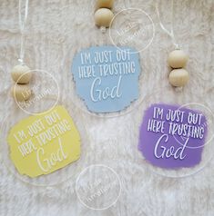 three acrylic ornaments with words on them