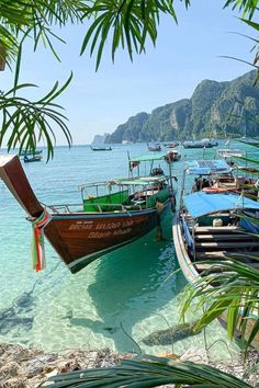 several boats are docked on the beach in clear water