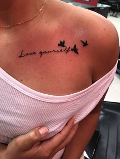 a woman's chest with the words love yourself written on it and birds flying around her