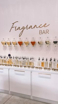 a counter with many different types of liquors on it and a sign that says frangance bar