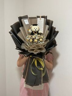 a woman holding a bouquet of flowers with a teddy bear on it's back