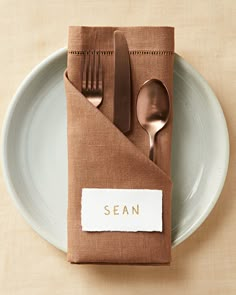 a napkin with a fork, spoon and knife on it is sitting on a plate