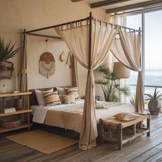 a bedroom with a canopy bed and wooden flooring next to a large window overlooking the ocean