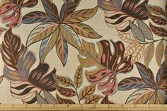 a close up view of a fabric with leaves on it and a ruler in the foreground