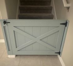 an open gate in the middle of a hallway with stairs and carpeted flooring