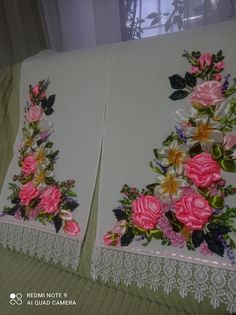 two white pillows with pink and yellow flowers on them